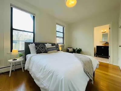 a bedroom with a large white bed and two windows at VAN VORST HOUSE Prime Location Minutes to NYC in Jersey City