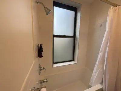 a bathroom with a bath tub and a window at VAN VORST HOUSE Prime Location Minutes to NYC in Jersey City