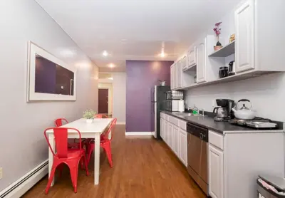 a small kitchen with a table and red chairs at Bright and Beautiful 3 BR Apt Midtown West in New York