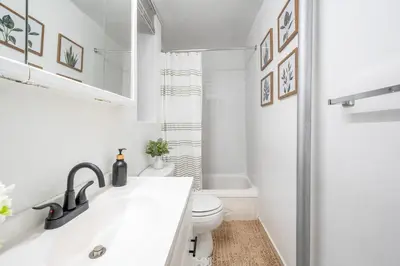 a white bathroom with a toilet and a sink at Bright and Beautiful 3 BR Apt Midtown West in New York
