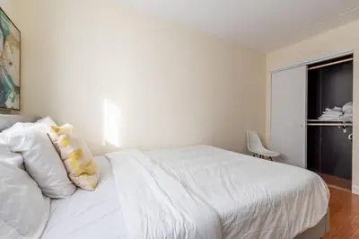 a bedroom with a white bed and a window at Stunning 3 Bed Fully Furnished Apt in New York