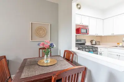 a kitchen with a table with a vase of flowers on it at Stunning 3 Bed Fully Furnished Apt in New York