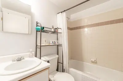 a bathroom with a sink and a toilet and a tub at Stunning 3 Bed Fully Furnished Apt in New York