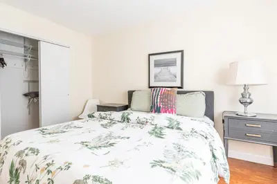 a bedroom with a bed with a floral bedspread at Stunning 3 Bed Fully Furnished Apt in New York