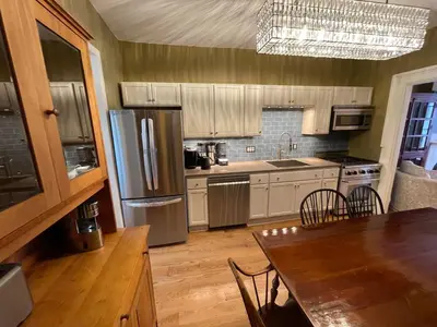 a kitchen with a dining table and a refrigerator at Downtown 3BR duplex full kitchen parking off i-787 in Albany
