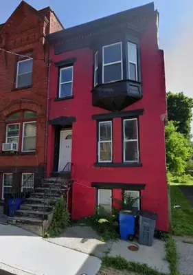 a red house with a white door at Downtown 3BR duplex full kitchen parking off i-787 in Albany