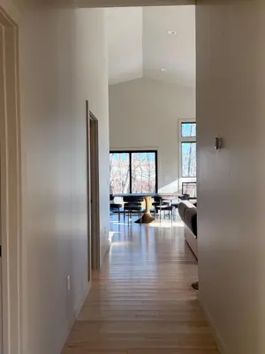a living room with white walls and a wooden floor at Luxury Catskills Sauna Retreat -Haven On The Manor in Livingston Manor