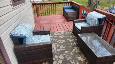 a porch with three wicker chairs on a deck at Cozy Cabin in Tobyhanna