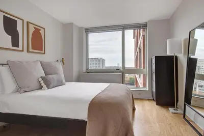 a bedroom with a large bed and a large window at Blueground East Harlem pool nr Central Park NYC-687 in New York