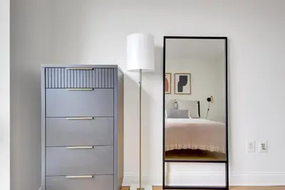a bedroom with a dresser and a mirror at Blueground East Harlem pool nr Central Park NYC-687 in New York