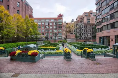 a garden with flowers in the middle of a city at Blueground East Harlem pool nr Central Park NYC-687 in New York