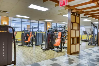 a gym with treadmills and elliptical machines at Blueground East Harlem pool nr Central Park NYC-687 in New York