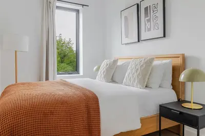 a white bedroom with a bed and a window at Blueground South Williamsburg washer nr Domino Park NYC-1866 in Brooklyn