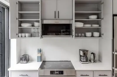 a kitchen with white cabinets and a stove top oven at Blueground South Williamsburg washer nr Domino Park NYC-1866 in Brooklyn
