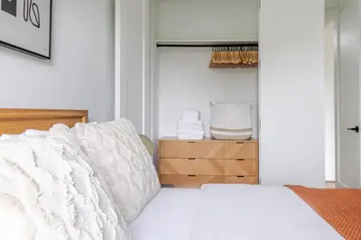 a bedroom with a white bed with a wooden headboard at Blueground South Williamsburg washer nr Domino Park NYC-1866 in Brooklyn