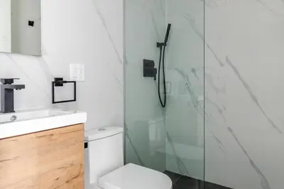 a bathroom with a toilet and a glass shower at Blueground South Williamsburg washer nr Domino Park NYC-1866 in Brooklyn
