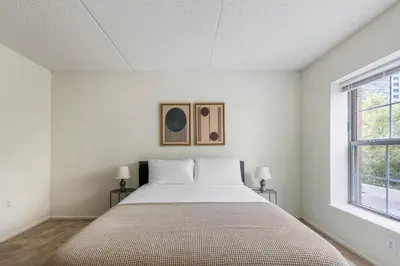 a white bedroom with a bed and two windows at Blueground Hudson Exchange pool nr Liberty Park NYC-1890 in New York