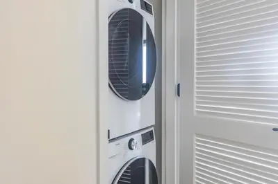 a washer and dryer in a cabinet next to a door at Blueground Southside rooftop nr McCarren Park NYC-2012 in Brooklyn