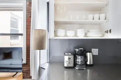 a kitchen with a coffee maker and plates on a shelf at Blueground West Village terrace nr Hudson River Park NYC-2123 in New York