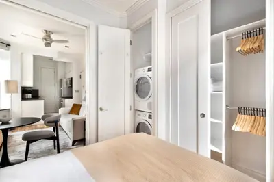 a white bedroom with a washer and dryer at Blueground West Village terrace nr Hudson River Park NYC-2123 in New York