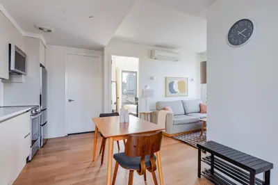 a kitchen and a living room with a table and chairs at Blueground Williamsburg rooftop nr Domino Park NYC-2204 in Brooklyn