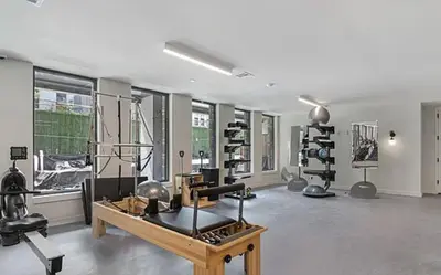 a room with a gym with a table and equipment at Blueground Williamsburg rooftop nr Domino Park NYC-2204 in Brooklyn