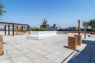 a patio with a pavilion and a white bench at Blueground Williamsburg rooftop nr Domino Park NYC-2204 in Brooklyn