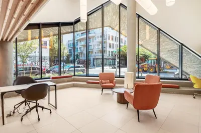 a lobby with chairs and a table and windows at Blueground Williamsburg rooftop nr Domino Park NYC-2204 in Brooklyn
