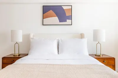 a bedroom with a white bed with two lamps at Blueground Yorkville pool nr Central Park NYC-2218 in New York