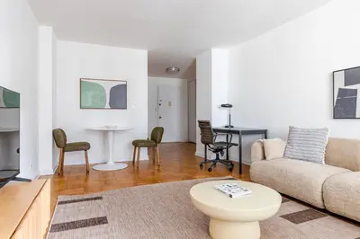 a living room with a couch and a table at Blueground Yorkville pool nr Central Park NYC-2218 in New York