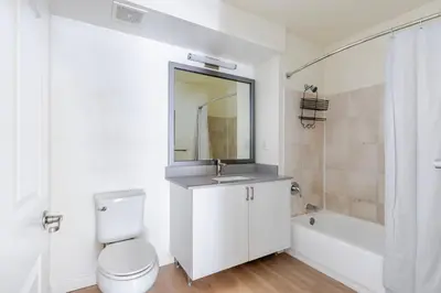 a bathroom with a toilet and a sink and a tub at Blueground Hudson Exchange pool nr Liberty Park NYC-2222 in New York