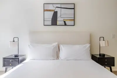 a bedroom with a white bed with two night stands at Blueground Hudson Exchange pool nr Liberty Park NYC-2222 in New York