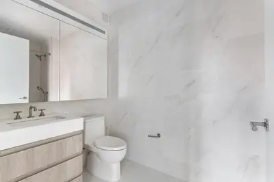 a white bathroom with a toilet and a sink at Blueground Gramercy Park rooftop nr Flatiron NYC-2203 in New York