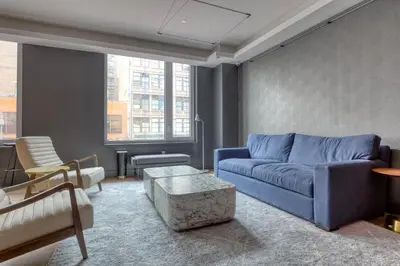 a living room with a blue couch and a table at Blueground Gramercy Park rooftop nr Flatiron NYC-2203 in New York