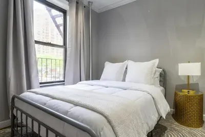 a white bedroom with a large bed and a window at Suite 24 - East Harlem, Manhattan by Monthier in New York