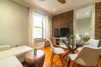 a living room with a glass table and a brick wall at Suite 24 - East Harlem, Manhattan by Monthier in New York