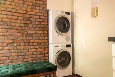 a washer and dryer next to a brick wall at Suite 24 - East Harlem, Manhattan by Monthier in New York