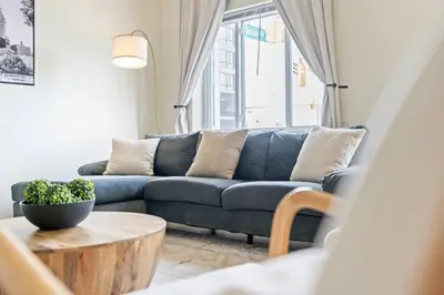 a living room with a blue couch and a table at Group Retreat 15Min to NYC, MetLife, Mall, FREE Pa in North Bergen