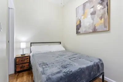a bedroom with a bed and a painting on the wall at Spacious 2BR - 15m to Times Square - FREE Parking in North Bergen