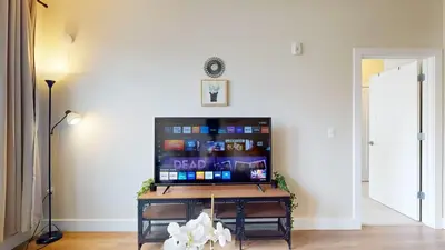 a living room with a flat screen tv at Modern Comforts Free Gym Access in Stamford