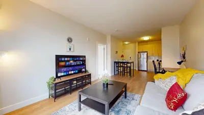 a living room with a white couch and a table at Modern Comforts Free Gym Access in Stamford