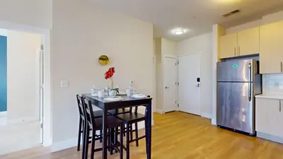 a kitchen with a table with chairs and a refrigerator at Modern Comforts Free Gym Access in Stamford