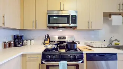 a kitchen with a stove and a microwave at Modern Comforts Free Gym Access in Stamford