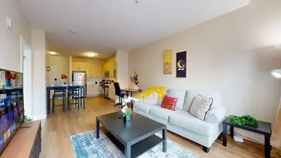 a living room with a white couch and a table at Modern Comforts Free Gym Access in Stamford