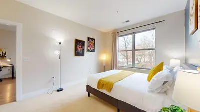 a bedroom with a large bed and a window at Modern Comforts Free Gym Access in Stamford