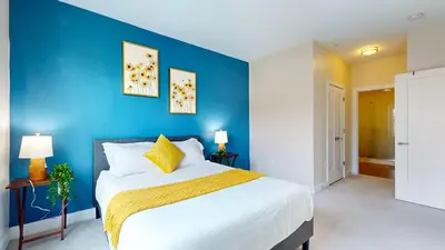 a bedroom with a large bed with a blue wall at Modern Comforts Free Gym Access in Stamford