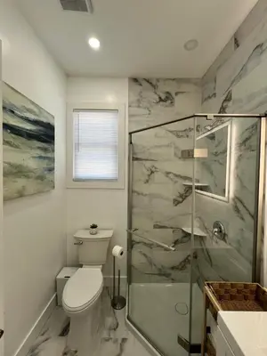 a bathroom with a toilet and a glass shower at 2Bed Gem-15min to NYC-3min Walk to Bus-Train in North Bergen