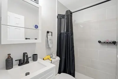 a bathroom with a shower and a toilet and a sink at Spacious 2BR Apt with Balcony only 15 Min Bus to Manhattan in Jersey City