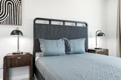 a bedroom with a bed with two lamps on tables at Spacious 2BR Apt with Balcony only 15 Min Bus to Manhattan in Jersey City