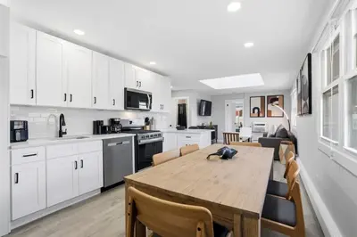 a kitchen and dining room with a wooden table at Spacious 2BR Apt with Balcony only 15 Min Bus to Manhattan in Jersey City
